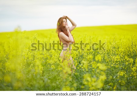 rapeseed field, yellow, red-haired naked girl standing