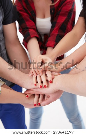 group of students in a circle of hands stacked together