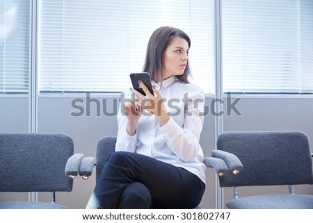 business woman with mobile phone sits in the office