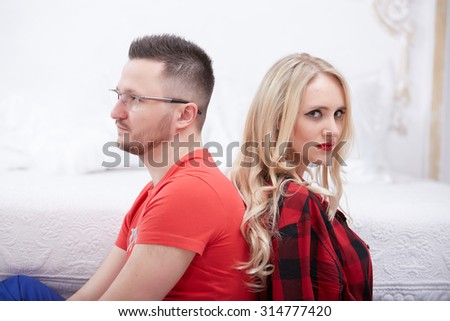 woman and a man in a quarrel sitting on the bed