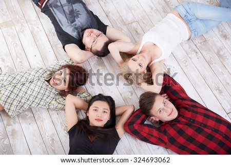 a group of cheerful students lying on the floor all around