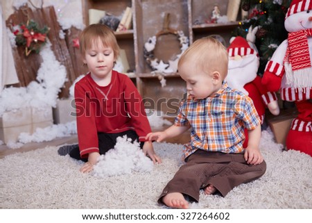 two brothers are playing under the Christmas tree