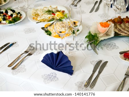 Wedding table with forks, wine glasses, knifes and food