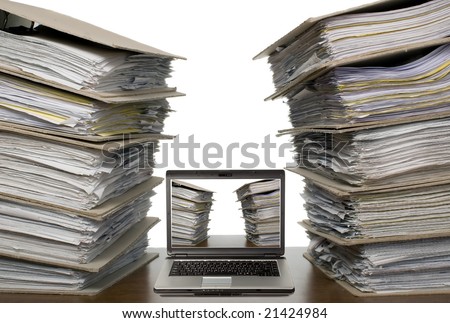 There is laptop near a lot of documents and catalogs