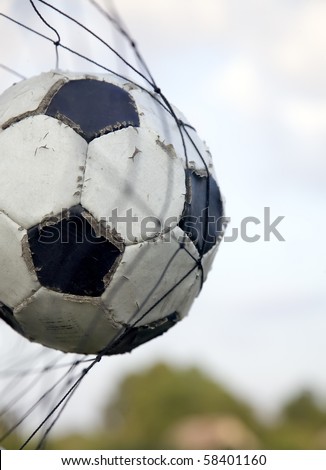 White and black soccer ball in net of gates