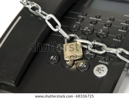 Black telephone is secured with metal chain and lock
