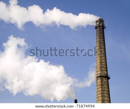 Chimney of factory with smoke on sky background