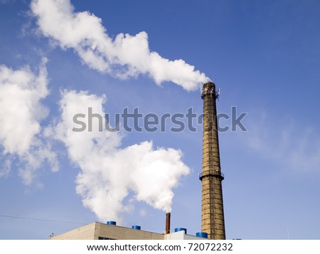 Chimney of factory with smoke on sky background