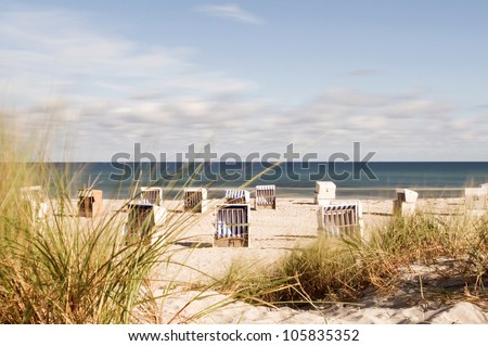 hooded beach chairs at the baltic sea, focus on the dune grass in foreground