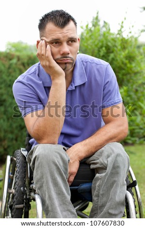 disabled young man in wheelchair with a pensive facial expression