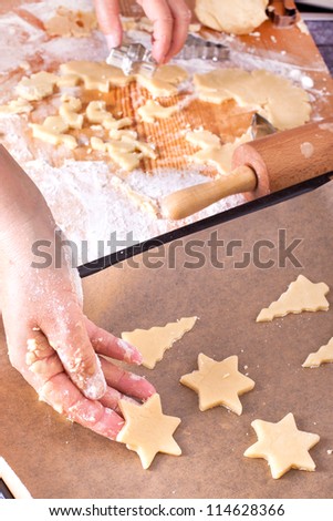 christmas cookies on a baking tray, woman is baking christmas cookies