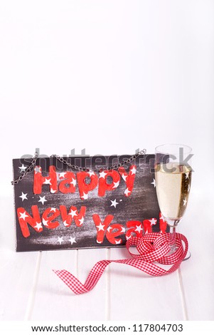 new years decoration with sparkling wine and a black board with happy new year text with white background