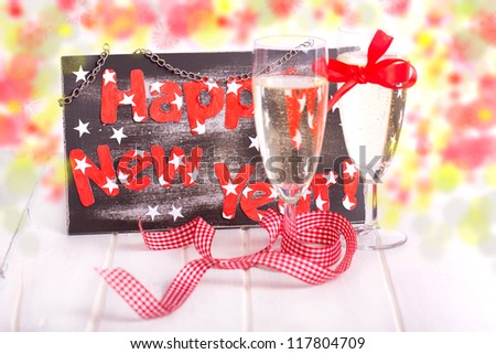new years decoration with sparkling wine and a black board with happy new year text