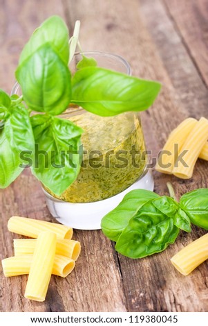 freshly made Basil pesto with fresh basil leaves, Glass with fresh made Pesto Sauce on wooden background