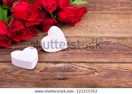 hearts and a bouquet of red roses on wooden board Valentines Day background hearts and a bouquet of red roses on wooden board Valentines Day background