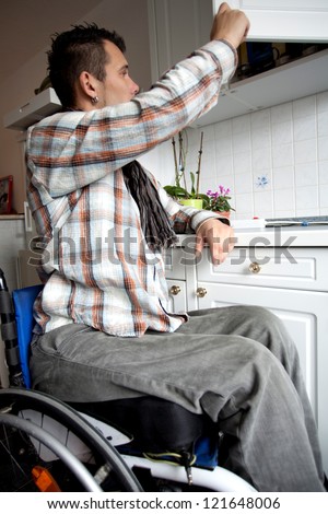 young man in wheelchair in Barrier-free apartment, disabled young man in the kitchen