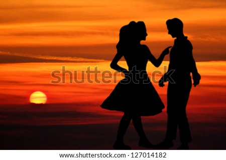 a young couple in love dancing in sundown, dancing man and woman
