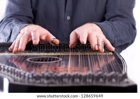 playing a traditional musical instrument, It belongs to the zither family of string instruments