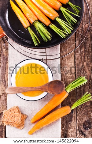 fresh carrot soup on old wooden table, bird`s eye view