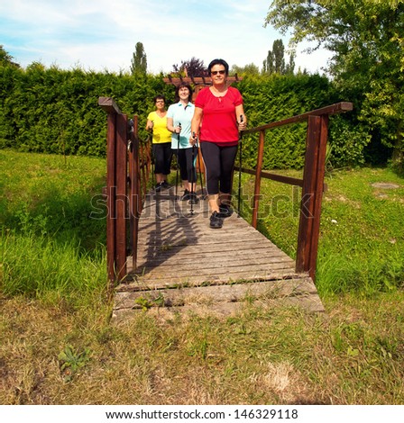 a Group of three adult woman have some fun while sports in leisure time, nordic walking