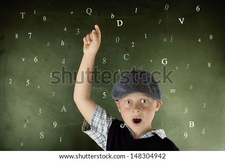 young school boy on a chalkboard with numbers and letters