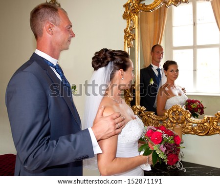 wedding day, bride and groom look in a big mirror in an old Castle, just married