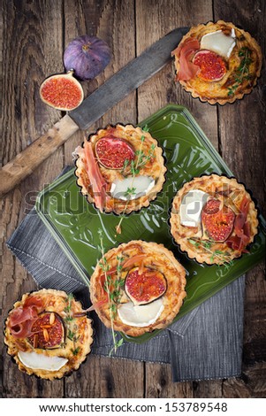 delicious tart or Quiche with figs and cheese on rustic table, birds eye view