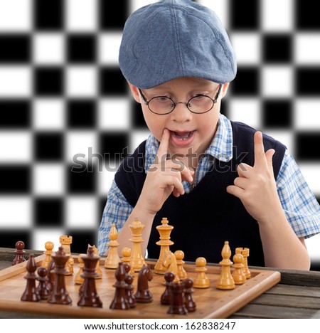 little boy plays chess, black and White chessboard in background