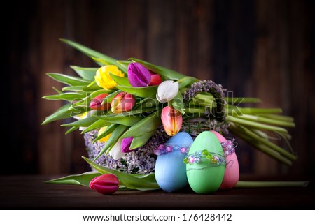 beautiful easter decoration at home, fresh tulips in a basket with easter eggs, mystic light scene