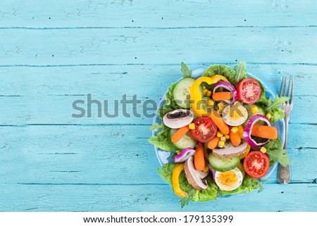 fresh salad on blue wooden table, bird`s eye view
