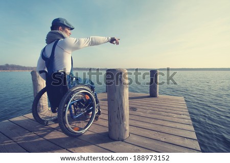 spring vacation: man in wheelchair enjoying outdoors beach