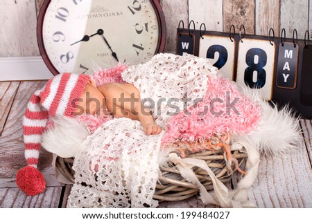 Dreaming Newborn Baby - naked in Hat on soft Blanket, with clock and board for birth time and birth date