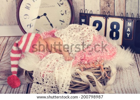 Dreaming Newborn Baby - naked in Hat on soft Blanket, with clock and board for birth time and birth date