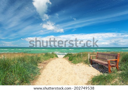 old wooden bench to rest on access to the beach, sunny summer day on Baltic sea