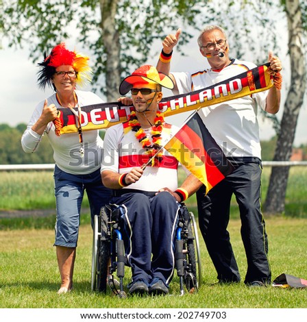 disabled Young man with wheelchair, with his family, supported the Team germany