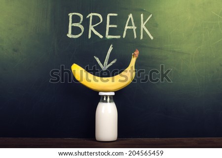 Break in school, a bottle of fresh milk and a banana in front of a blackboard with the note: break