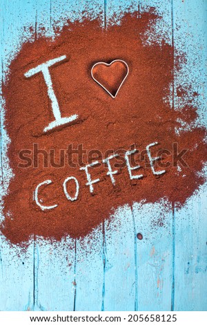 Words i love coffee written on ground coffee, coffee powder on blue wooden table