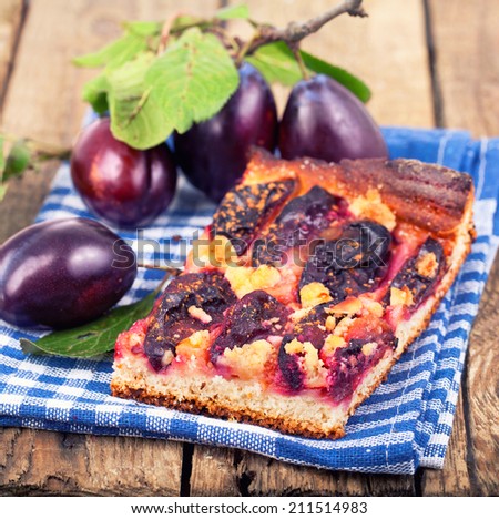 Plum cake with fresh plums on wooden table