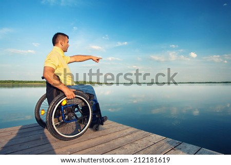 summer vacation: man in wheelchair enjoying outdoors beach