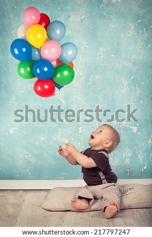 Smiling baby with balloons, colorful balloons and happy kid