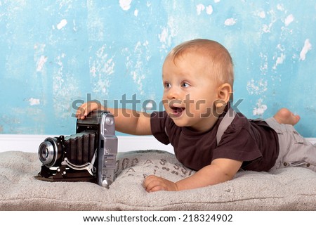 Baby is playing with old Retro camera, Baby with camera - vintage style