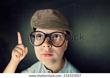 thinking Child with thick eyeglasses with blackboard in background