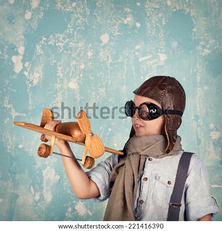 laughing boy in helmet  holding a toy airplane, Retro style, Vintage pilot (aviator) concept