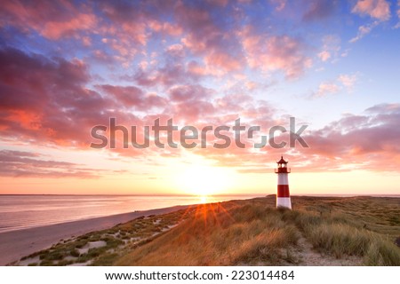 beautiful sunset landscape at the North sea with a lightning lighthouse, the Island of Sylt, Germany