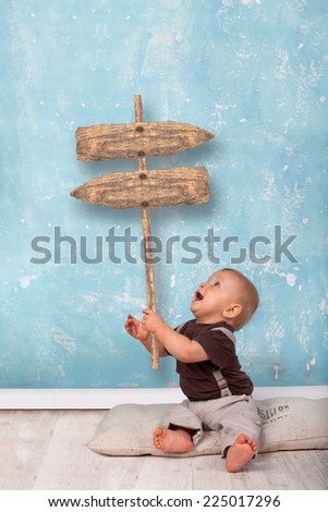 little boy holding an old wooden sign for your text, Marketing and Advertising concept