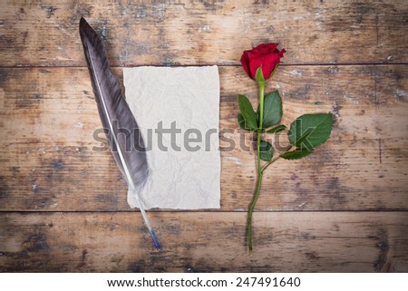 love letters, sentimental vintage background with antique paper, red rose and feather pen on old wooden background