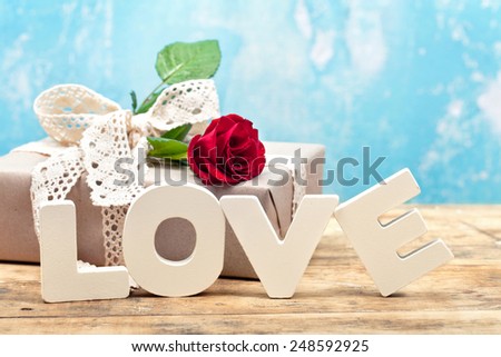 Gift box with red rose and wooden letters LOVE