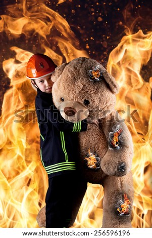 little boy in firefighter uniform save the teddy from the flames