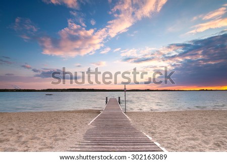 long boardwalk on the lake in the evening at sunset, silent and light