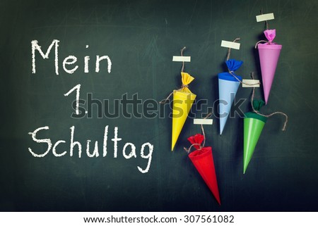 School cones on a chalkboard with german text: first day at school